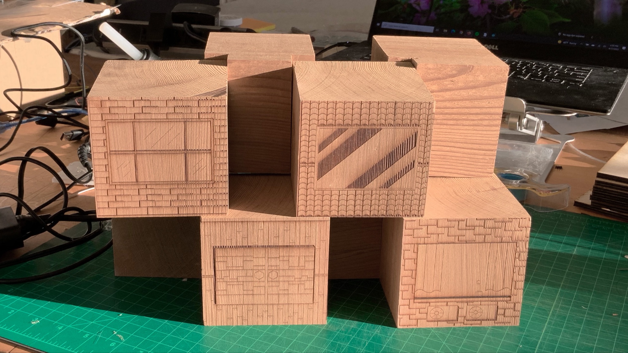Wooden laser-etched cube forms stacked on cutting mat — 3D masking prototype fabrication