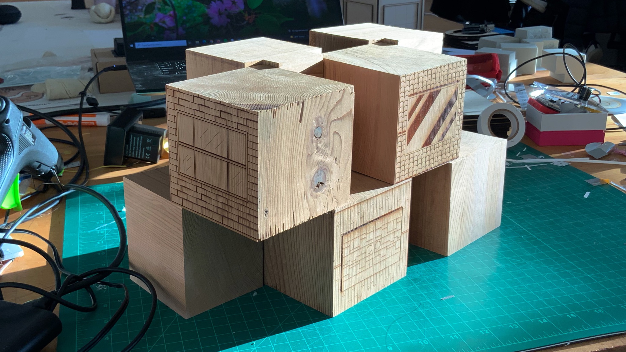 Assembled wooden cube cluster on cutting mat — testing the modular stacking configuration