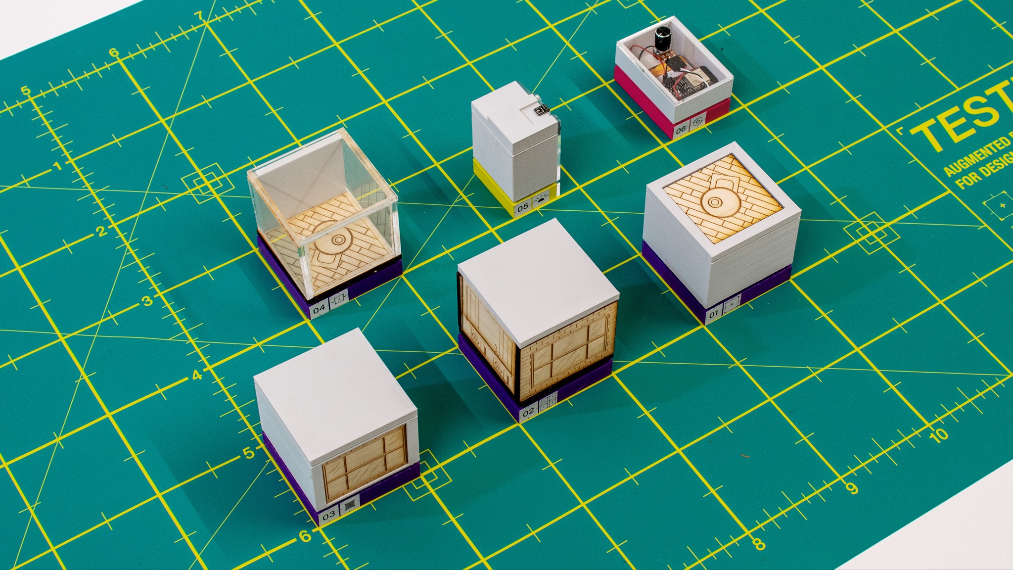 Close-up: five prototype tools laid out on cutting mat — image mapping cards, sensor modules, and cube forms