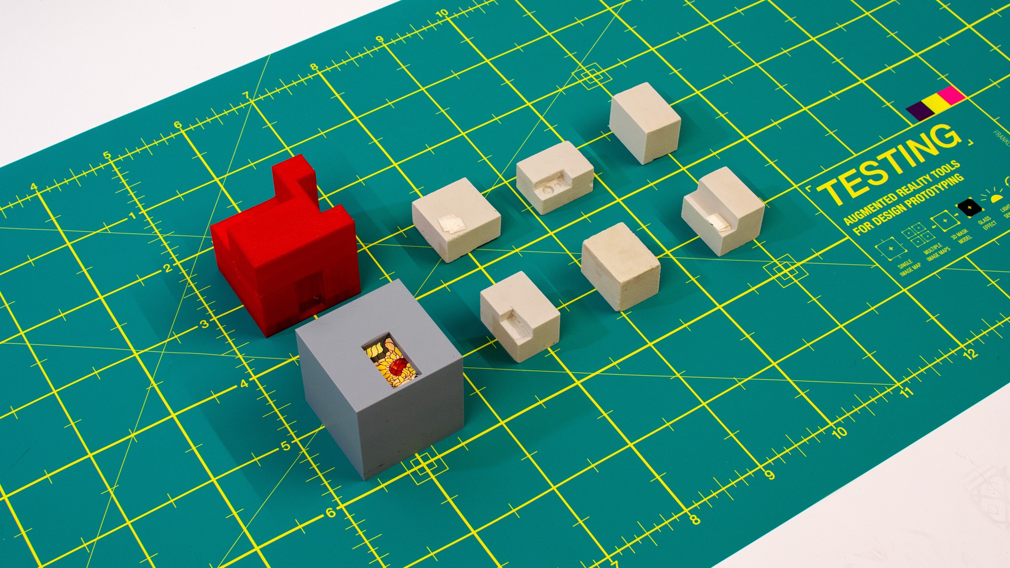 Cube prototype iterations including 3D printed red and grey forms — 3D masking development sequence