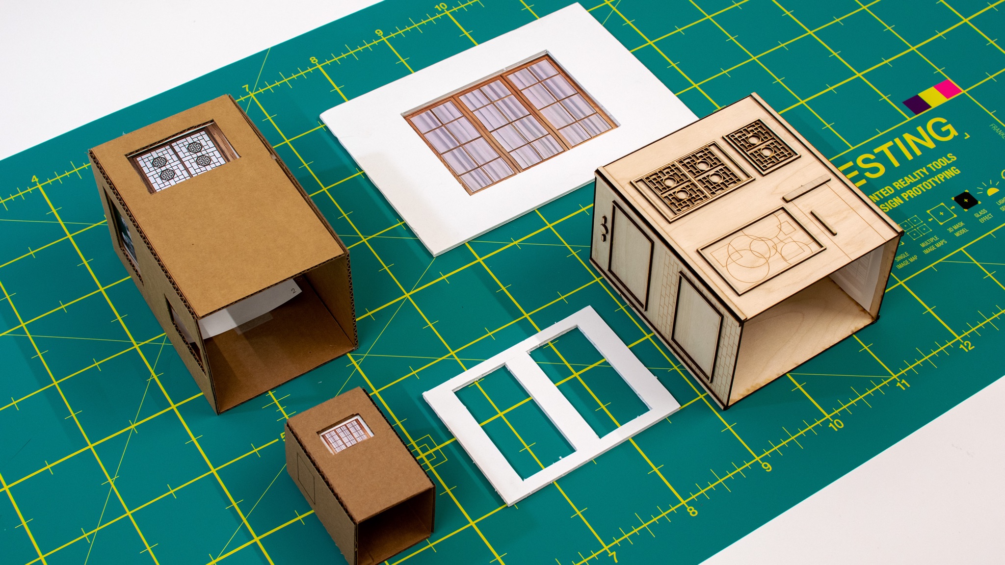 The first physical iterations: cardboard box prototypes — rapid tests of the cube form before committing to materials
