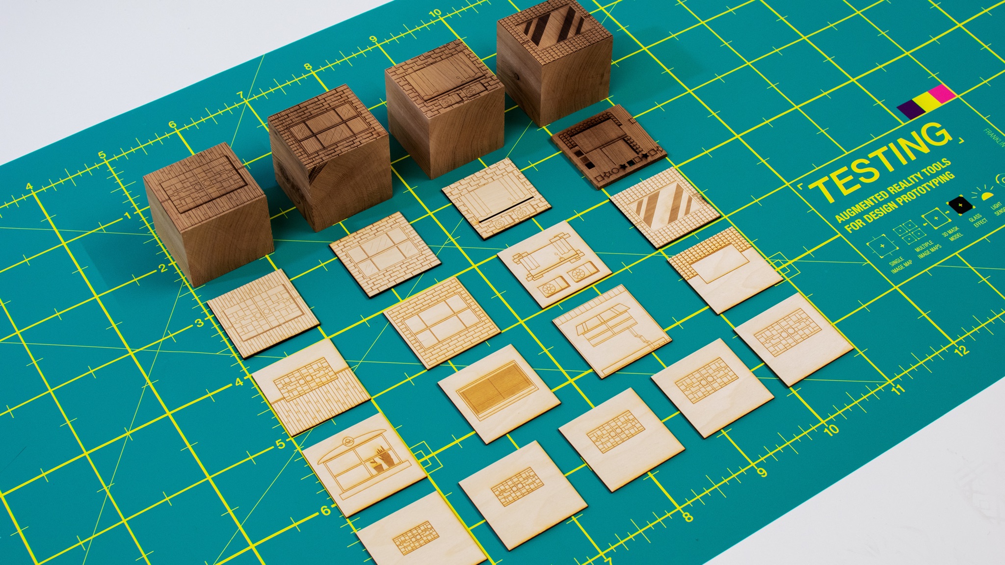 Wooden cube forms and laser-cut image mapping cards spread on cutting mat